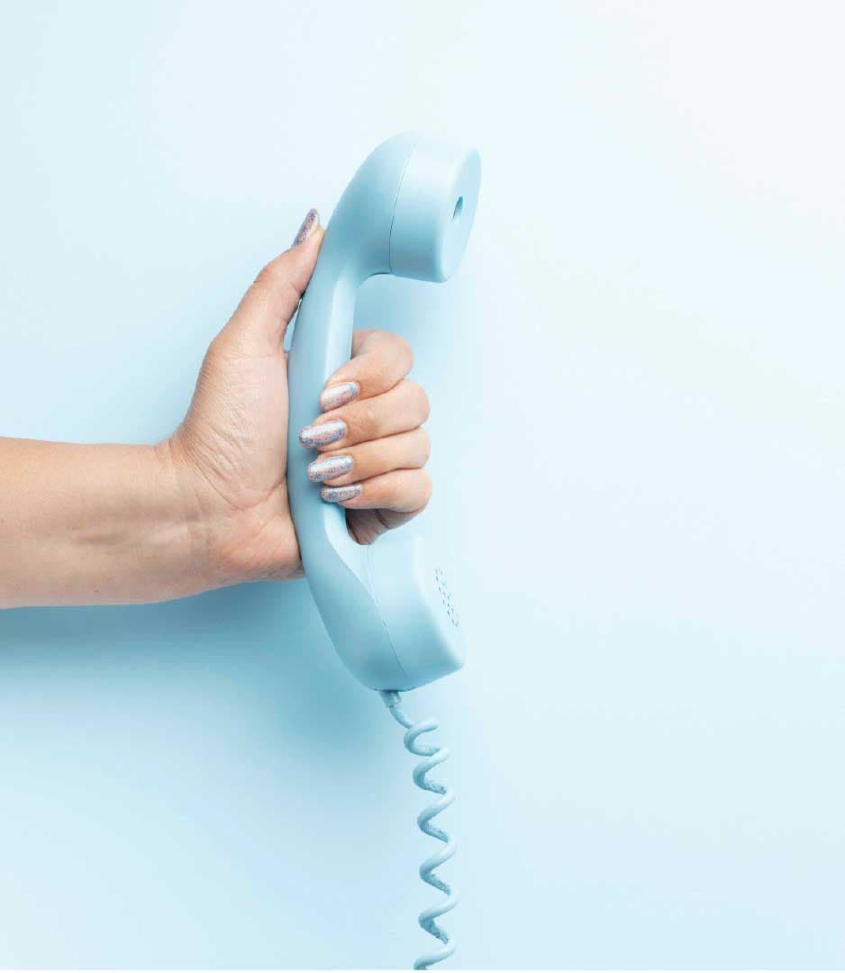 A hand holding a retro telephone handset